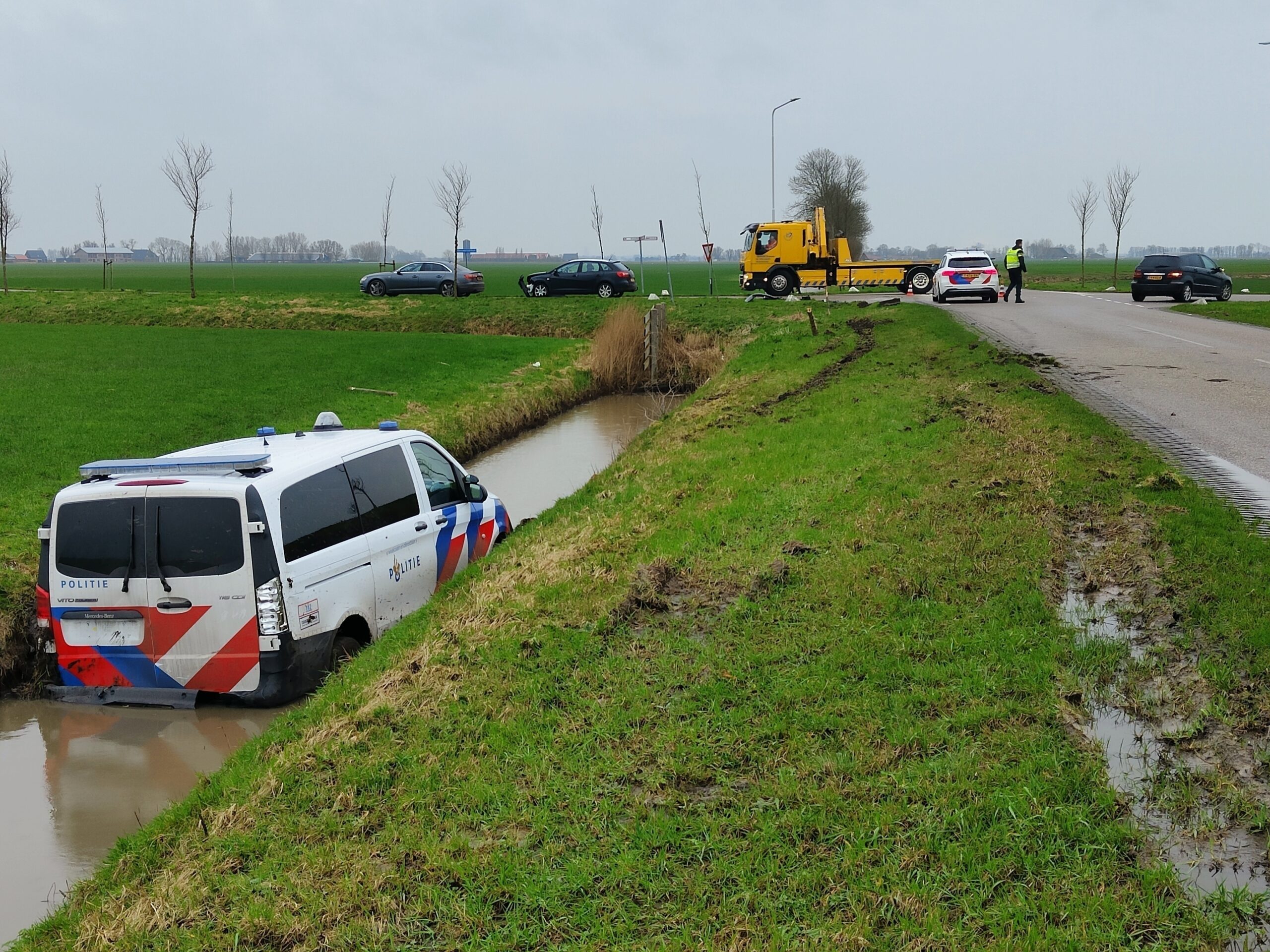 Politiebus belandt in water na aanrijding Iedyk Burdaard