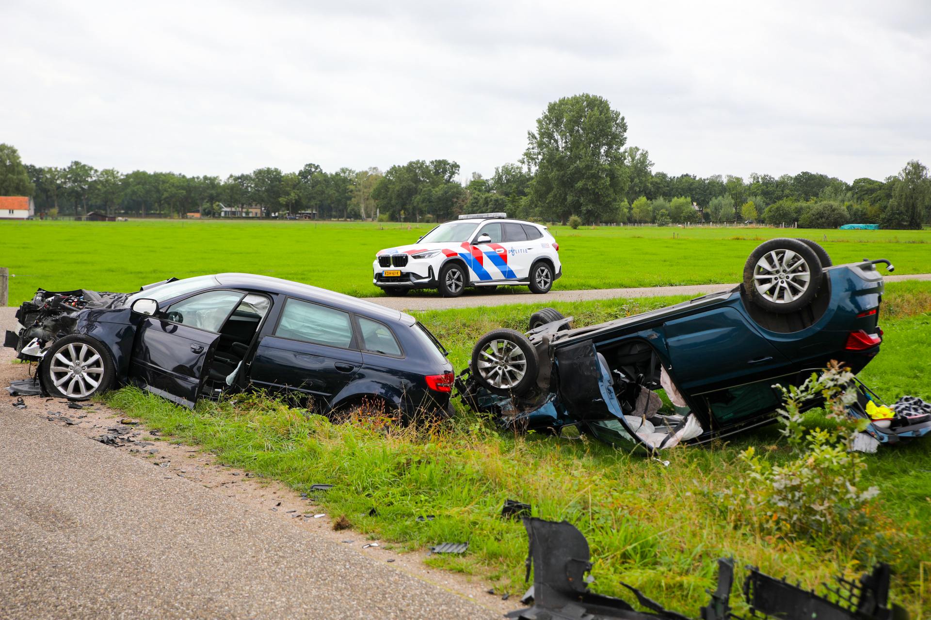 Zware botsing in Klarenbeek auto op de kop in weiland twee gewonden