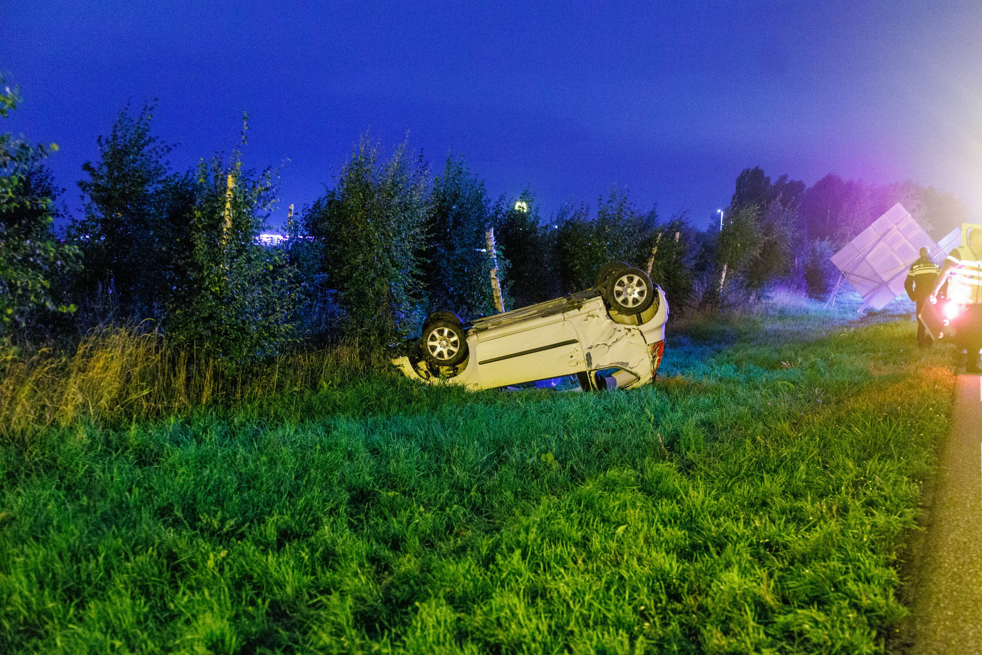 Bestuurder raakt verkeersbord en slaat over de kop; brandweer bevrijdt bestuurder