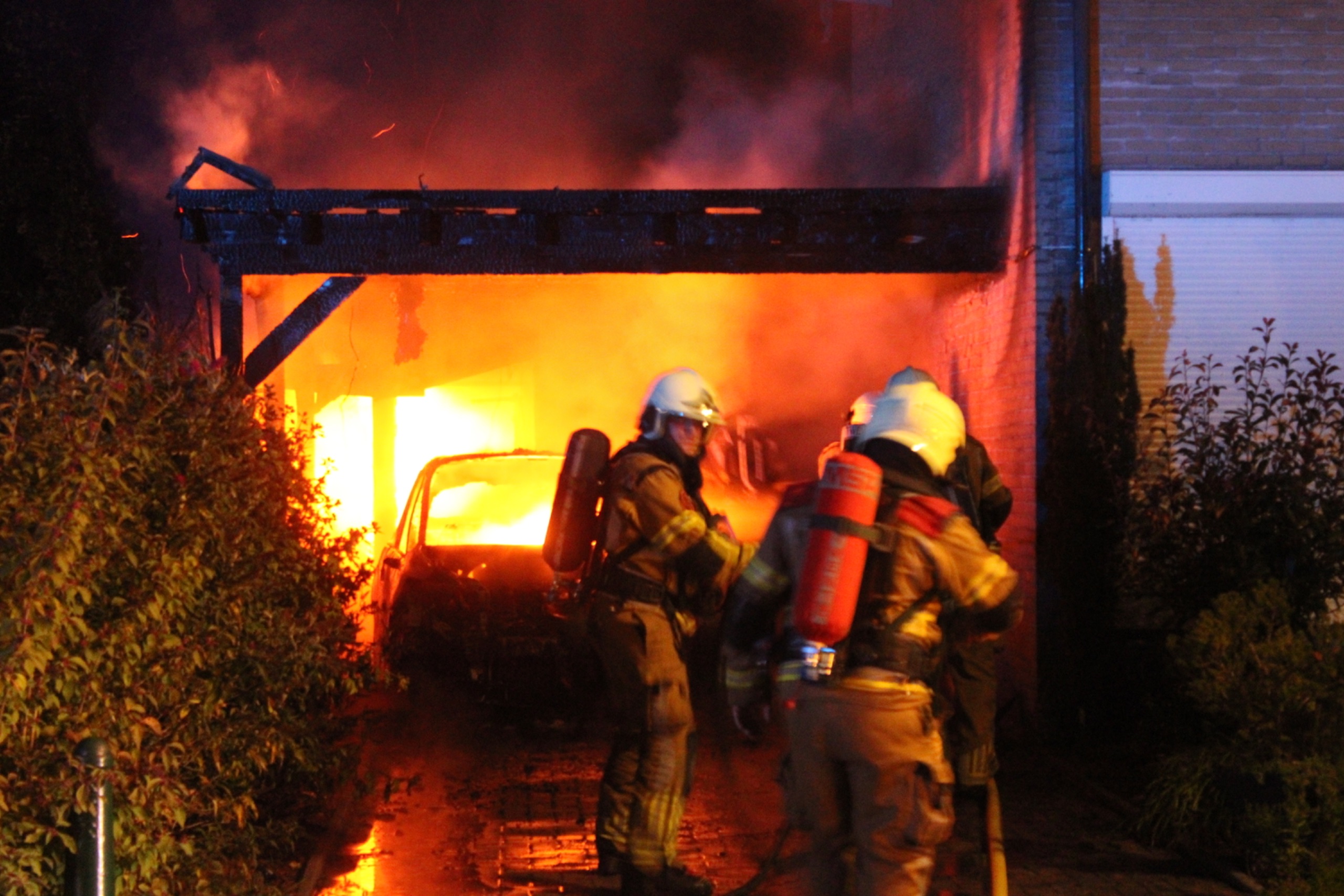 Auto en carport branden volledig uit; ook auto van de buren loopt schade op