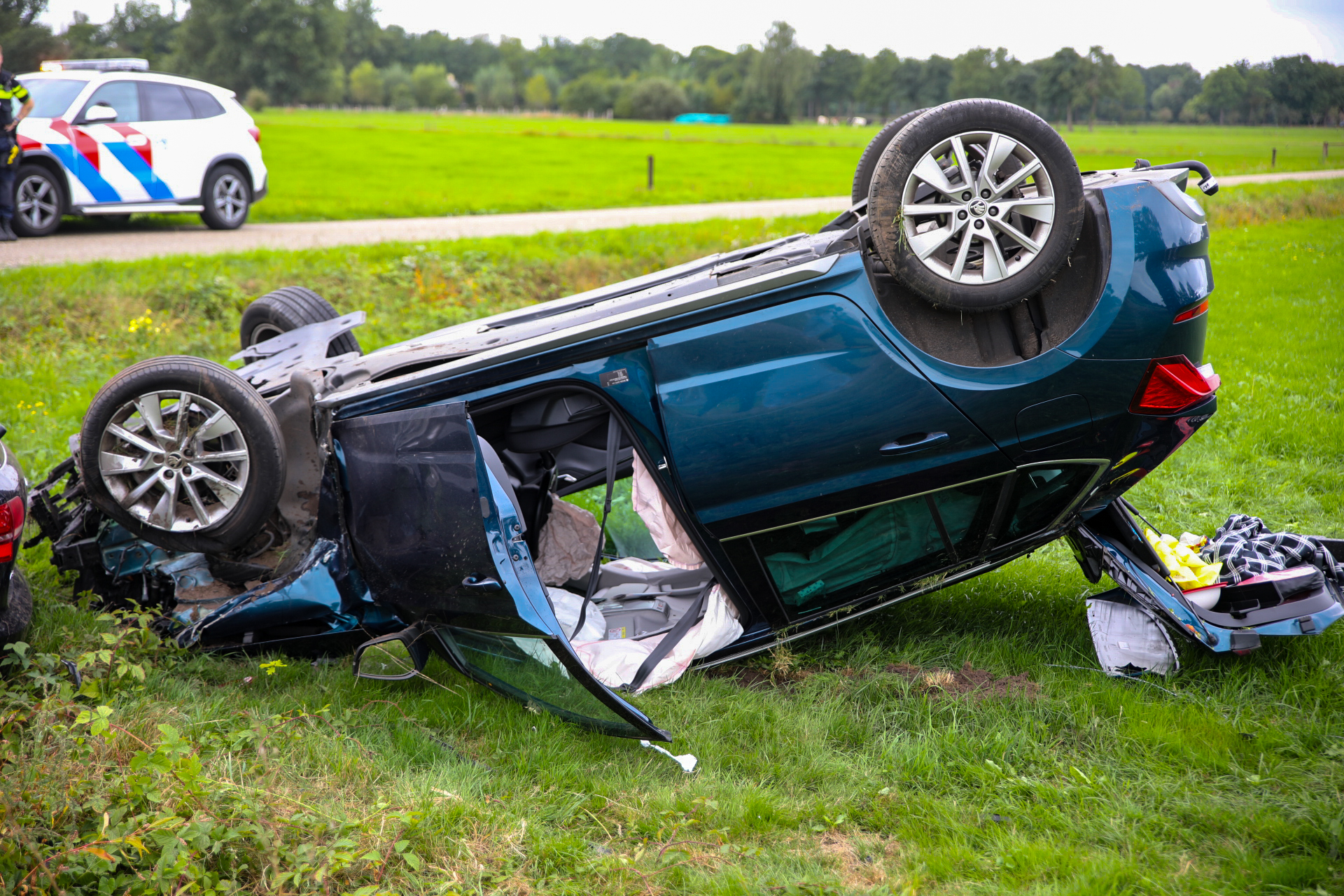 Zware botsing in Klarenbeek auto op de kop in weiland twee gewonden