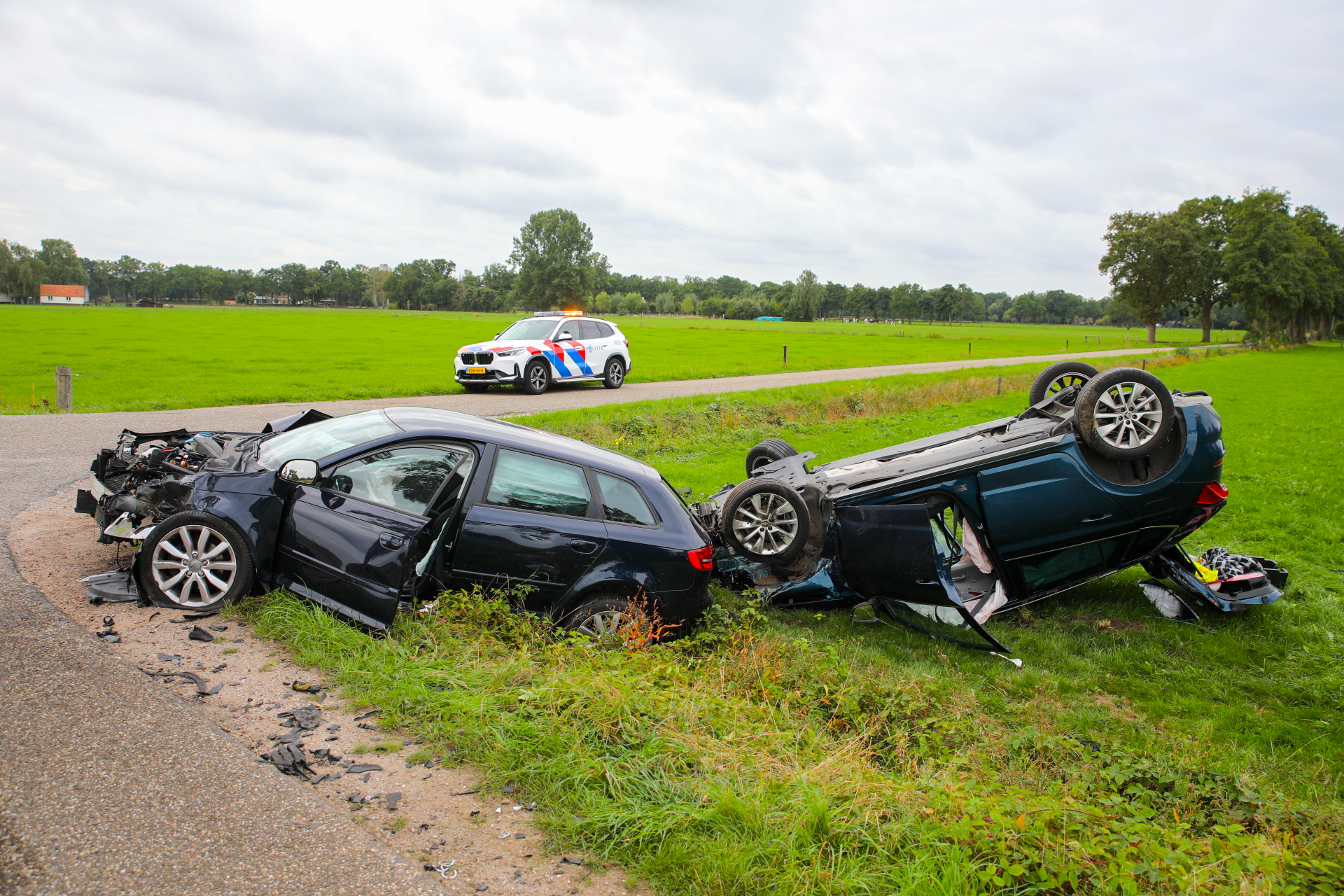 Zware botsing in Klarenbeek auto op de kop in weiland twee gewonden