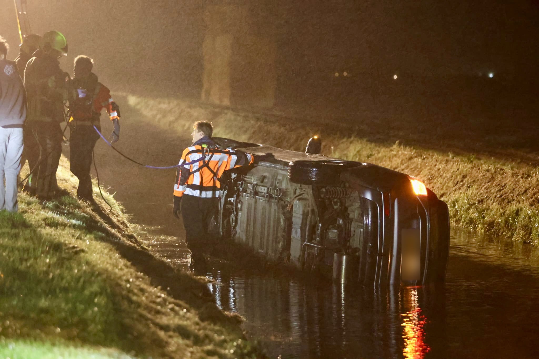 Auto belandt op zijkant in water na uitwijkmanoeuvre in Sint Maartensvlotbrug
